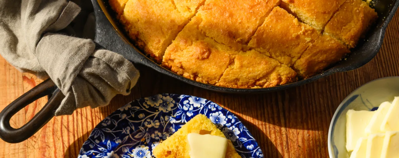 Cornbread in a cast-iron skillet, with butter on the side