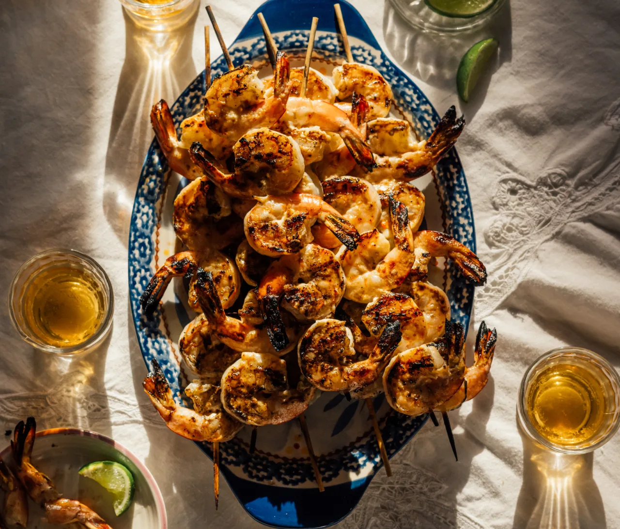 Grilled shrimp skewers on a blue and white platter